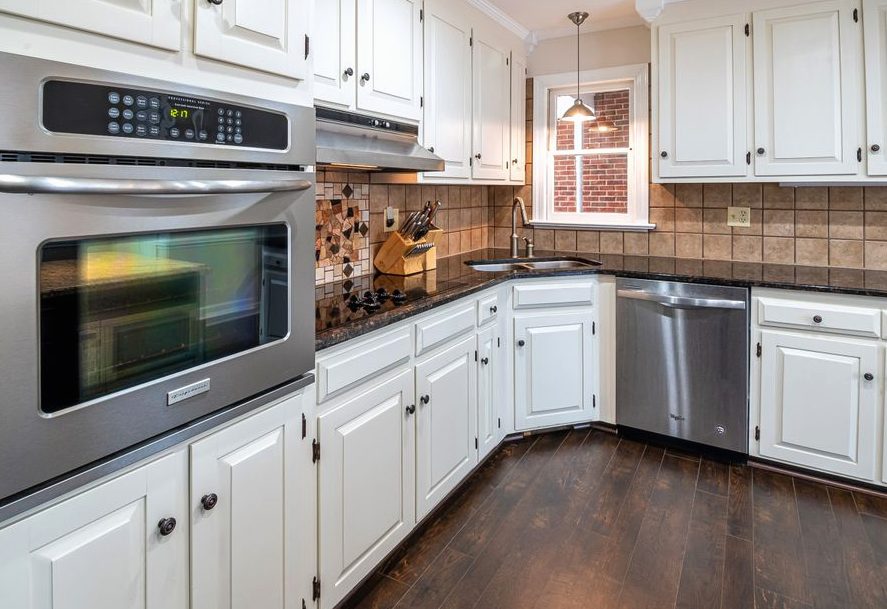 Cabinet Refacing, spacious kitchen featuring white cabinets, stainless steel appliances, and wooden flooring