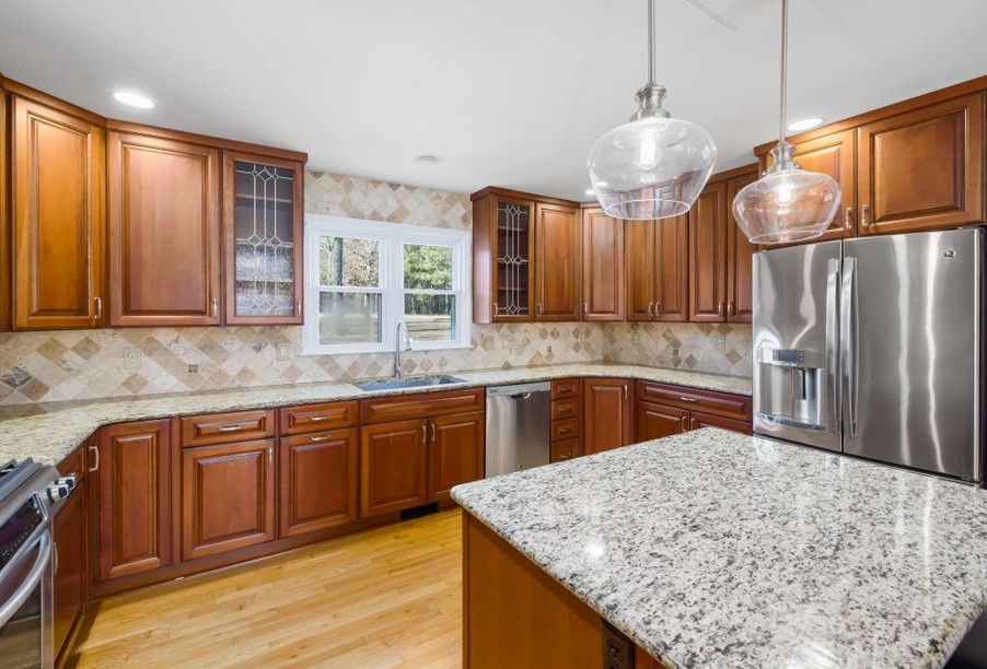 Spacious kitchen with wooden cabinets, granite island, and stainless steel appliances