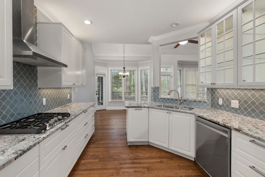 Spacious kitchen featuring granite countertops, hardwood floors, and elegant cabinets